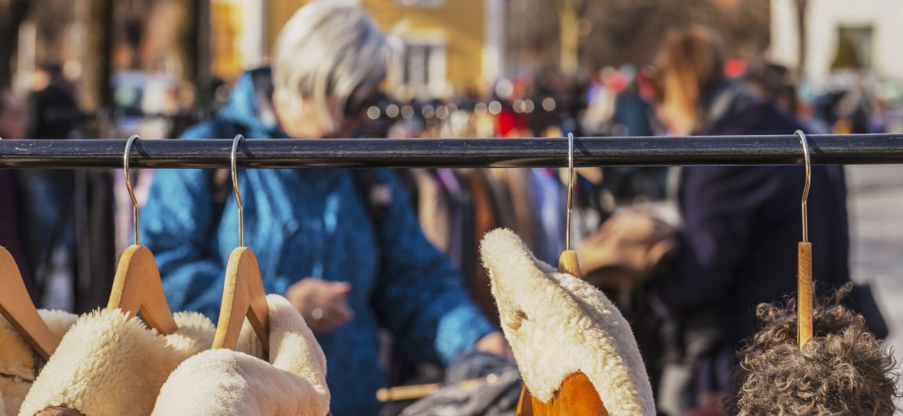 Woman behind a rack with cintage leather jackets with fur collar at outdoor market. This  outdoor market is open every Saturday and   is located only a few minutes away from from Gustav Vigeland park.