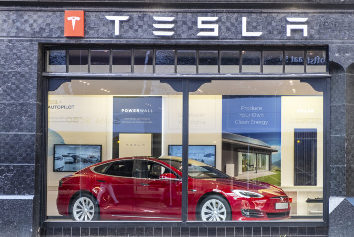 Tesla showroom in Amsterdam with a red Tesla Model S electric car on display inside