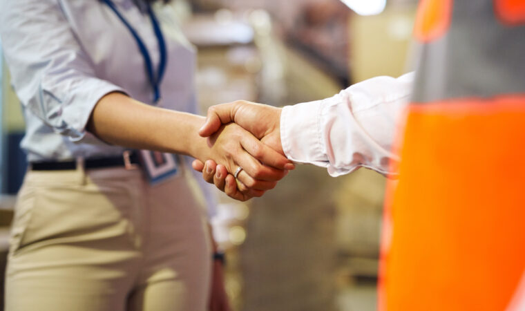 Logistics, deal and handshake with business people in warehouse for shipping, cargo and supply chain contract. Thank you, partnership and support with worker in factory plant for b2b distribution